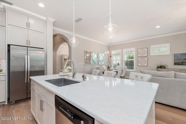 kitchen featuring sink, white cabinetry, light hardwood / wood-style flooring, stainless steel appliances, and decorative light fixtures