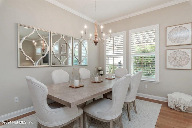 dining room featuring an inviting chandelier, hardwood / wood-style floors, and crown molding