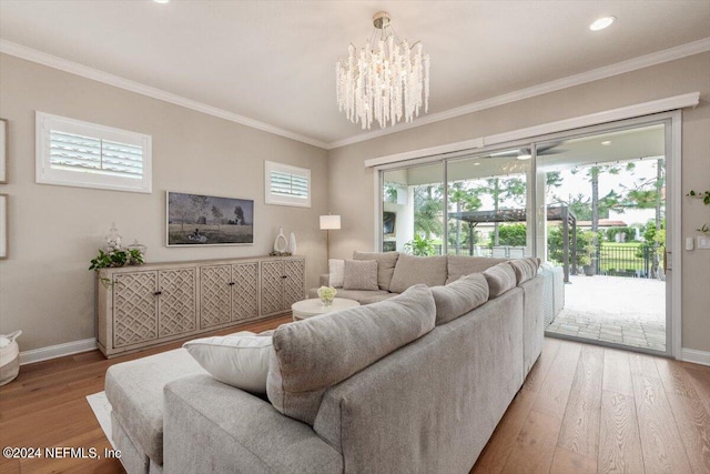 living room with a notable chandelier, crown molding, and hardwood / wood-style floors