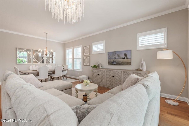 living room with a notable chandelier, crown molding, and hardwood / wood-style flooring