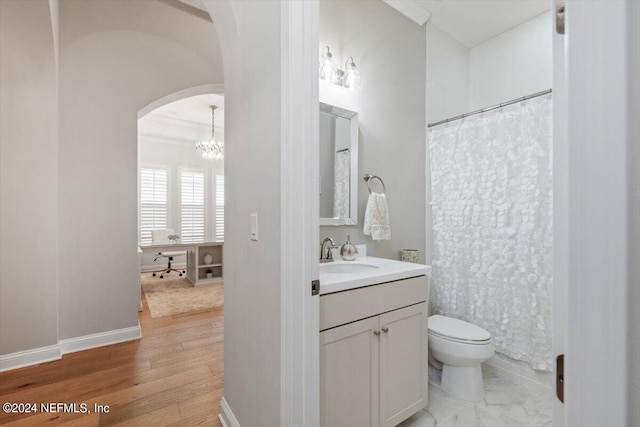 bathroom with vanity, ornamental molding, hardwood / wood-style floors, a chandelier, and toilet