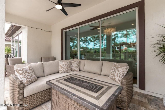 view of patio with ceiling fan and an outdoor living space with a fire pit