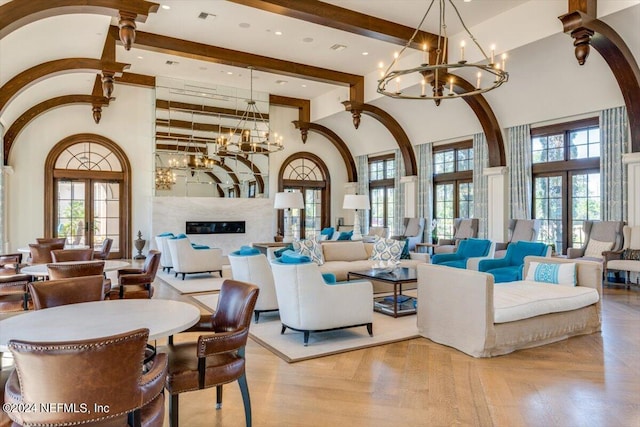 living room featuring an inviting chandelier, beam ceiling, high vaulted ceiling, and light parquet flooring