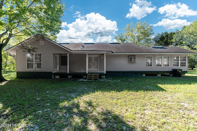 rear view of property featuring a lawn