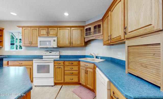 kitchen with a textured ceiling, white appliances, and sink