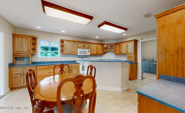 kitchen featuring white appliances, a center island, and washer and clothes dryer