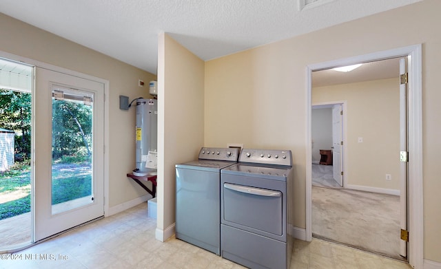 washroom with light carpet, a textured ceiling, washer and clothes dryer, and water heater