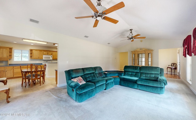 living room with ceiling fan, light carpet, and vaulted ceiling