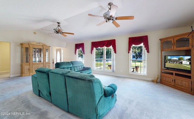 carpeted living room with ceiling fan and vaulted ceiling