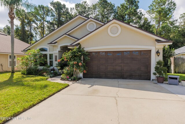 view of front of property featuring a garage and a front lawn