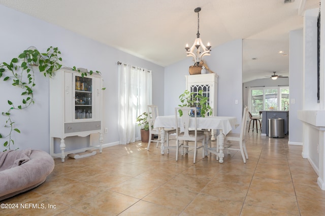 dining room with light tile patterned flooring, ceiling fan with notable chandelier, and vaulted ceiling