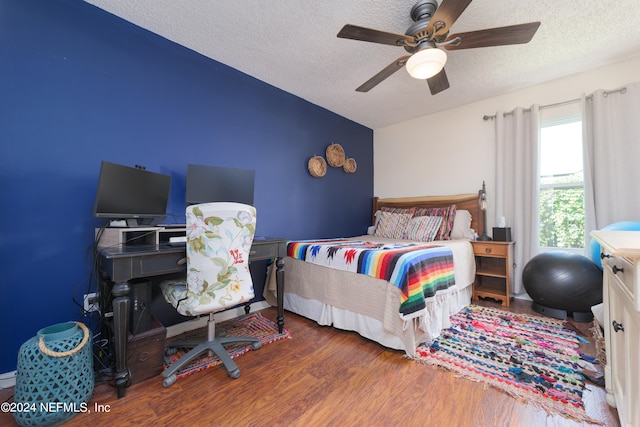 bedroom featuring ceiling fan, dark wood-type flooring, and a textured ceiling