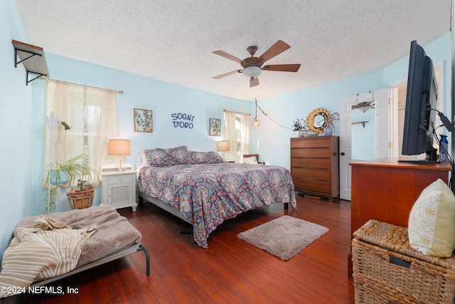 bedroom featuring ceiling fan, dark wood-type flooring, and a textured ceiling