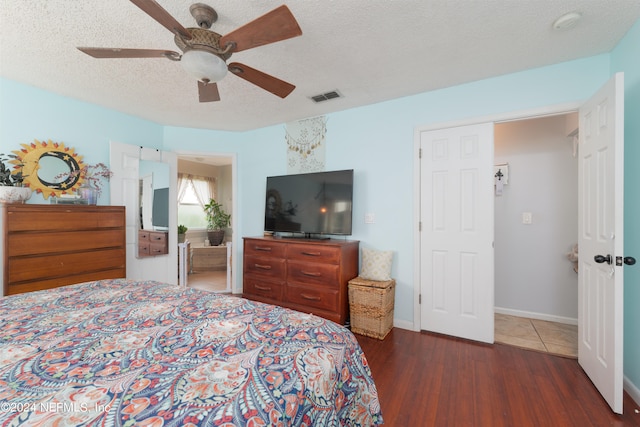 bedroom featuring ceiling fan, a textured ceiling, and dark hardwood / wood-style flooring