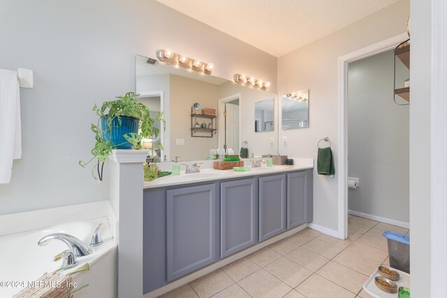 bathroom with vanity, a textured ceiling, a washtub, and tile patterned floors