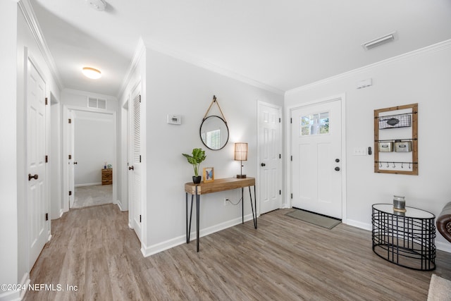 entrance foyer with light hardwood / wood-style floors and crown molding