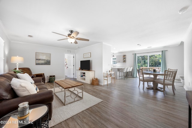 living room featuring ceiling fan, hardwood / wood-style floors, and ornamental molding