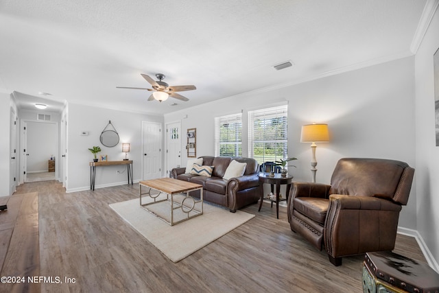 living room featuring ceiling fan, light hardwood / wood-style floors, and crown molding