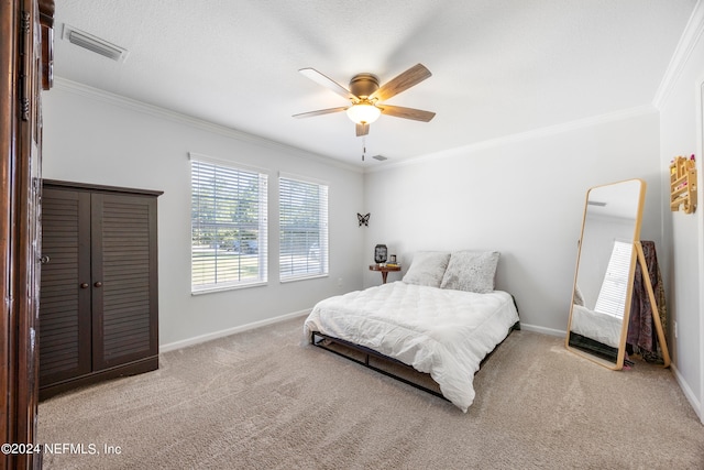 carpeted bedroom featuring ceiling fan and crown molding