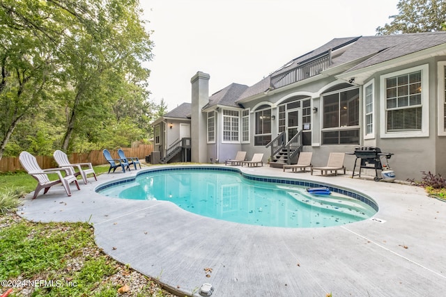 view of swimming pool with a grill and a patio area