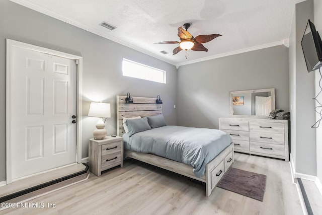 bedroom featuring ceiling fan, a textured ceiling, light hardwood / wood-style flooring, and crown molding