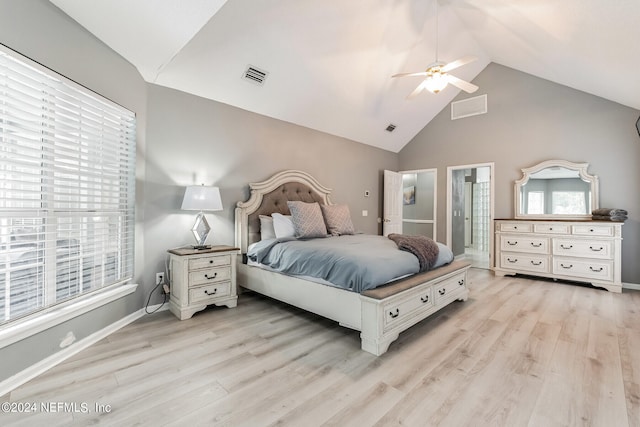 bedroom with lofted ceiling, light hardwood / wood-style floors, ceiling fan, and ensuite bath