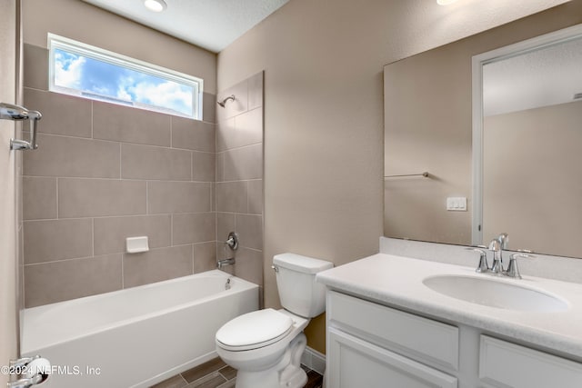 full bathroom featuring hardwood / wood-style floors, a textured ceiling, toilet, vanity, and tiled shower / bath