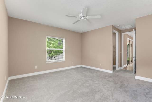 spare room featuring light carpet and ceiling fan