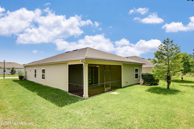 back of house featuring a lawn and a sunroom