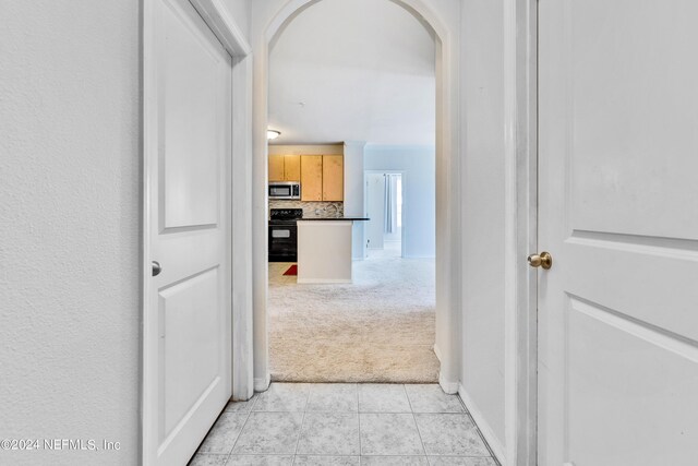 corridor featuring light colored carpet