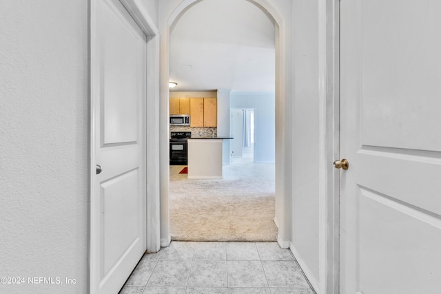 12700 Bartram Park Blvd Unit 124, Jacksonville, FL 32258 - hallway featuring light carpet, arched walkways, and light tile patterned floors