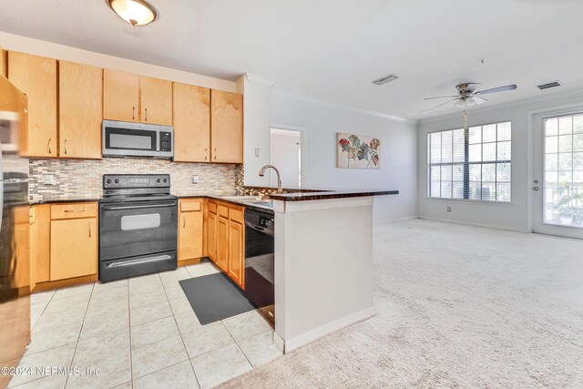 kitchen with kitchen peninsula, light tile patterned floors, decorative backsplash, and black appliances