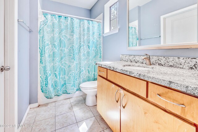 full bathroom featuring shower / tub combo with curtain, vanity, toilet, and tile patterned flooring