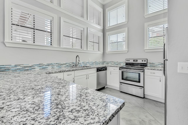 12700 Bartram Park Blvd Unit 124, Jacksonville, FL 32258 - kitchen with white cabinets, a sink, stainless steel appliances, and light stone counters