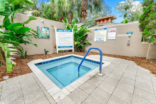 view of pool with a hot tub