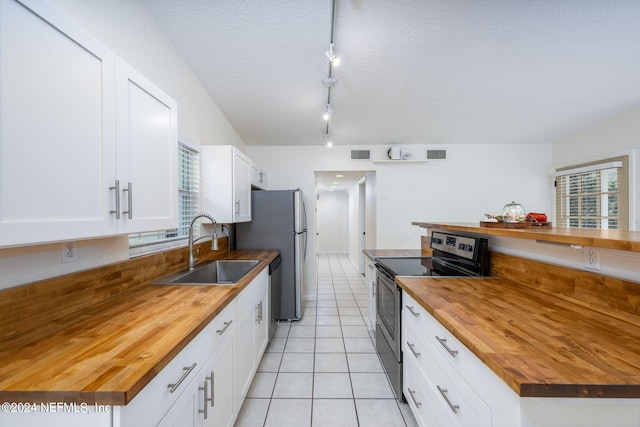 kitchen featuring sink, appliances with stainless steel finishes, white cabinetry, and wood counters