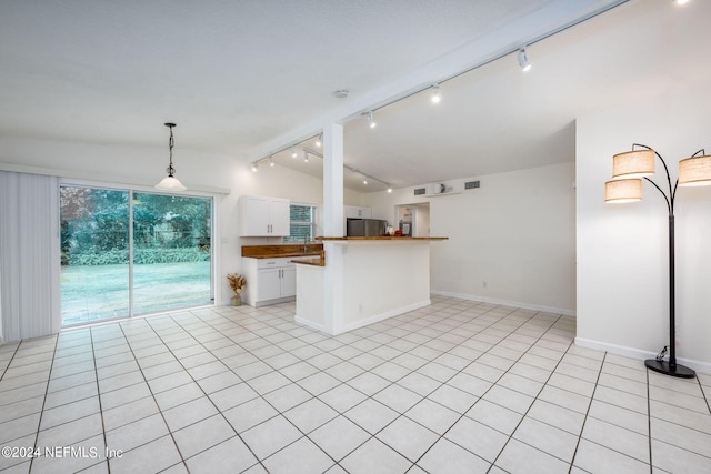 kitchen with vaulted ceiling with beams, white cabinets, wooden counters, rail lighting, and stainless steel refrigerator