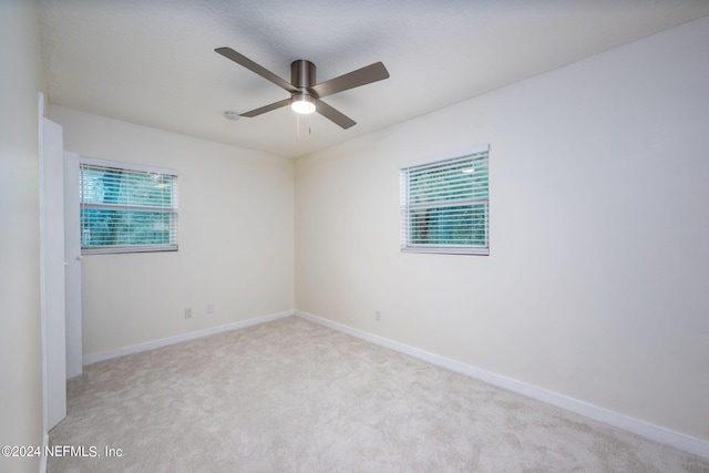 spare room with a textured ceiling, ceiling fan, and light colored carpet