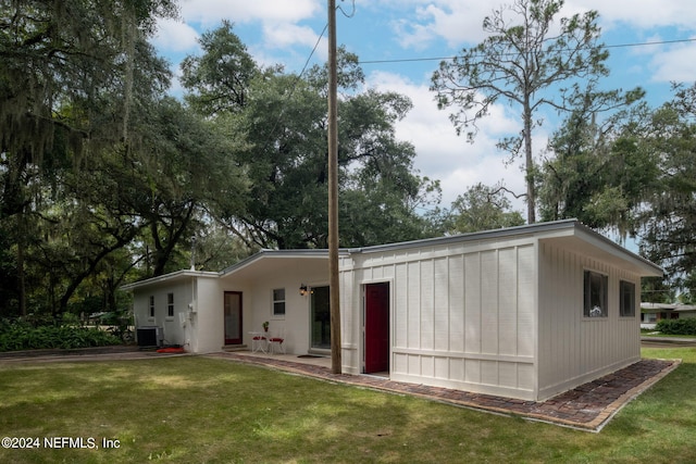 back of house featuring a yard and central air condition unit