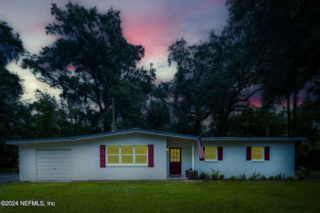 ranch-style home with a lawn and a garage