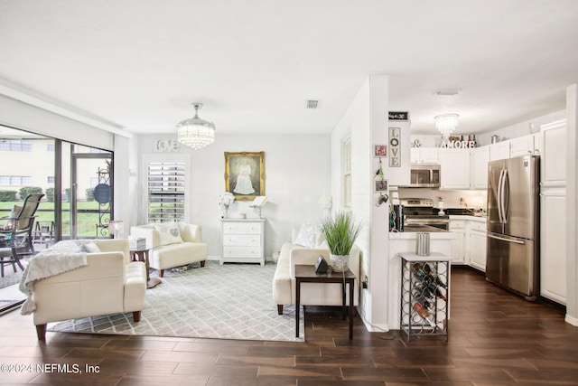 living room featuring dark hardwood / wood-style flooring and an inviting chandelier