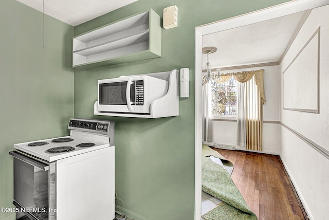 kitchen featuring a notable chandelier, white appliances, visible vents, baseboards, and wood-type flooring