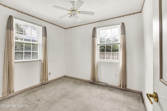 unfurnished room with crown molding, plenty of natural light, a ceiling fan, and light colored carpet