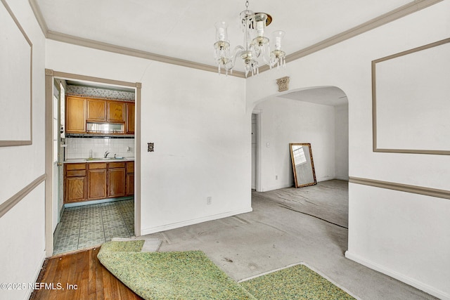 dining space with a chandelier, arched walkways, crown molding, and baseboards