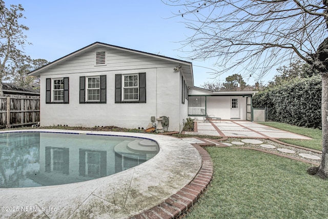 exterior space with a patio, a lawn, fence, and a fenced in pool