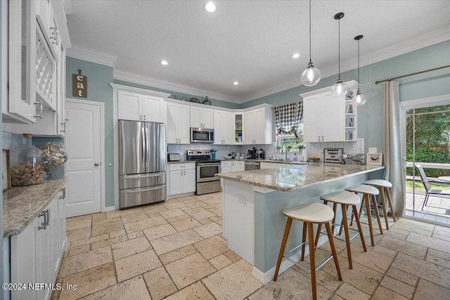 kitchen with decorative backsplash, stainless steel appliances, white cabinetry, and pendant lighting