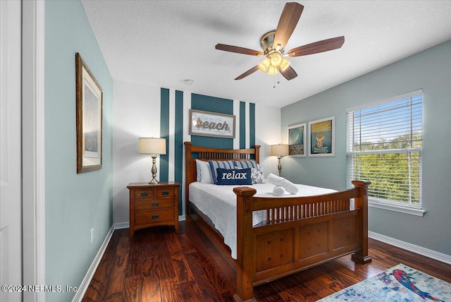 bedroom featuring ceiling fan, dark wood-type flooring, and a textured ceiling