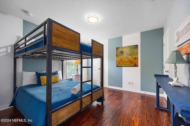 bedroom with a textured ceiling and dark hardwood / wood-style floors