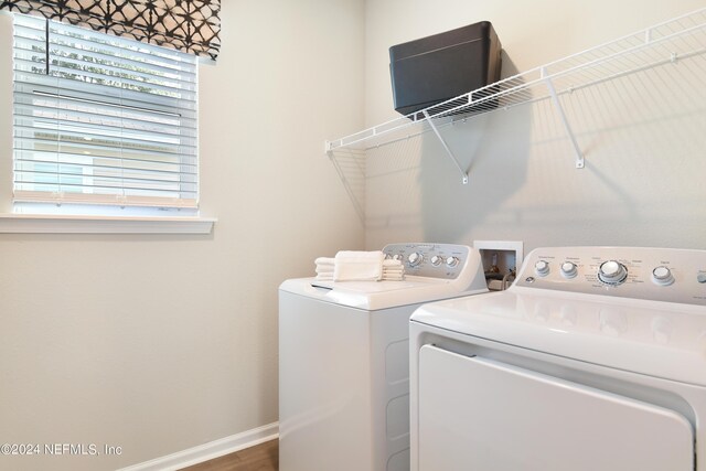 clothes washing area featuring washing machine and dryer and hardwood / wood-style floors