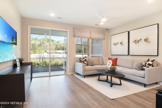 living room featuring light hardwood / wood-style floors and ceiling fan